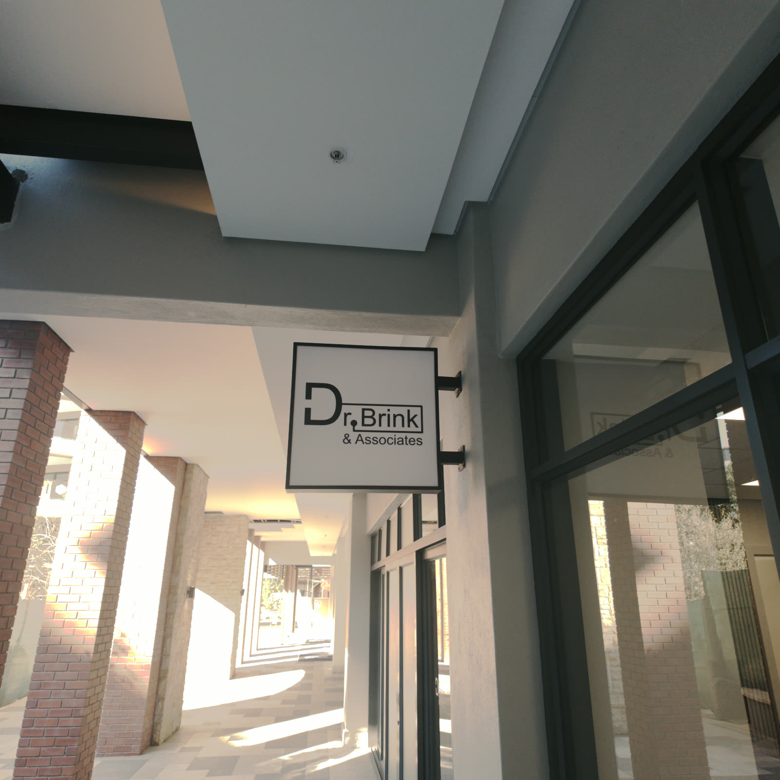 Dr Brink and Associates sign mounted above the covered entrance walkway at City Centre, Steyn City